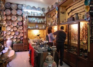 Una turista regateando en una tienda de artesanía y antigüedades.